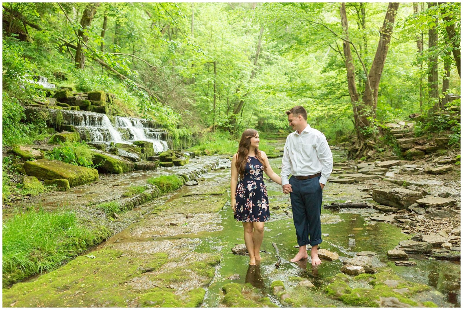 Couple standing by a waterfall during their engagement session at Shaker Village